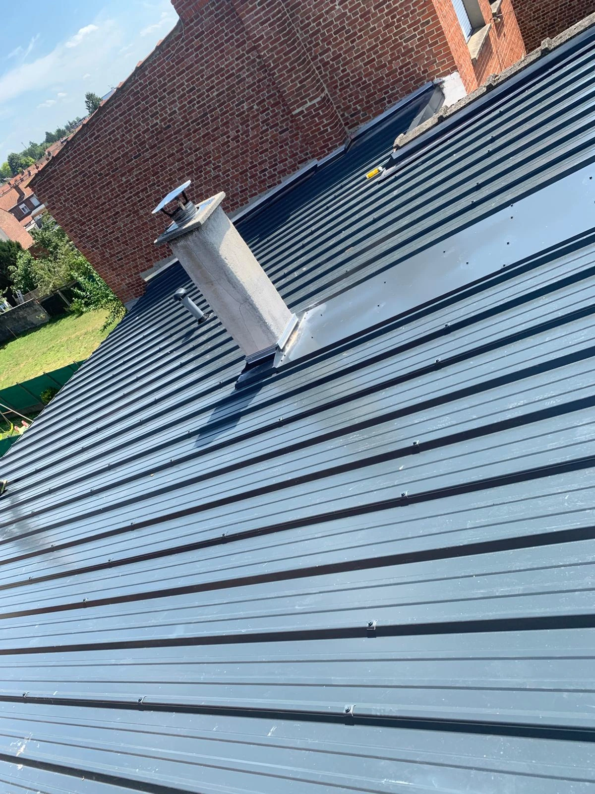 Toiture en bac acier gris avec sortie de cheminée — rénovation Full Renov'Habitat